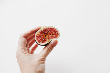 hand holding a fig cut in half