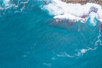 Fototapeta premium Aerial view of waves splashing on beach