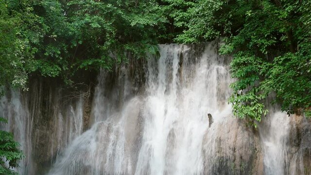 Beautiful Sai Yok Noi waterfall flowing on limestone in tropical rainforest at Kanchanaburi
