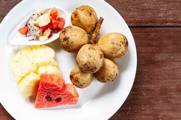 Mixed fruit plate on brown wooden table