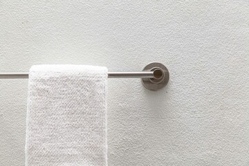 Clean white towels hang on stainless steel rails in the bathroom