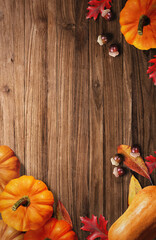 Pumpkin and Autumn Leaves on Wooden Background