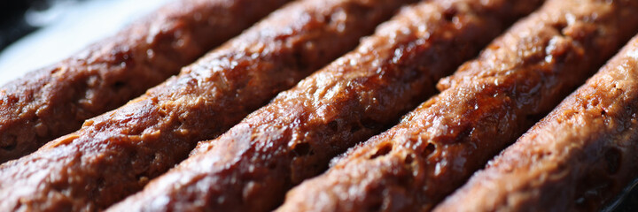 Pork sausages are fried in pan closeup