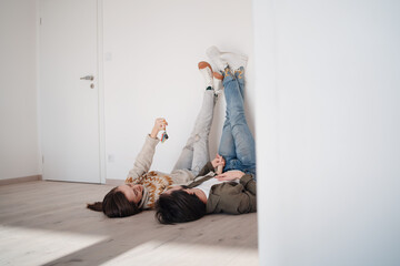 Young couple with keyslying on floor and moving in new flat, new home and relocation concept.