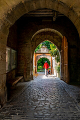 Fototapeta na wymiar people enjoy bicycle ride along the romantic street in Bavaria near medieval city of Rothenburg