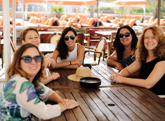 Women best friends sitting in summer cafe on the beach