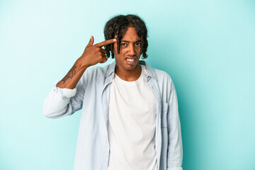 Young african american man isolated on blue background showing a disappointment gesture with forefinger.