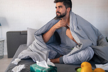 Sick man measuring temperature at home