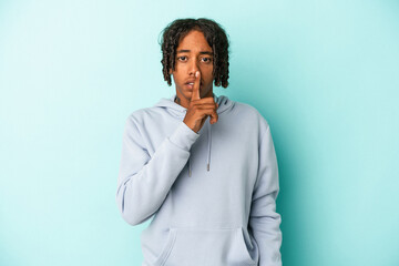 Young african american man isolated on blue background keeping a secret or asking for silence.