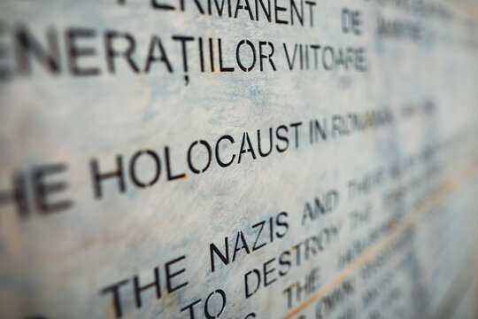 Shallow depth of field (selective focus) image with Holocaust history text inside the Romanian Holocaust Memorial.