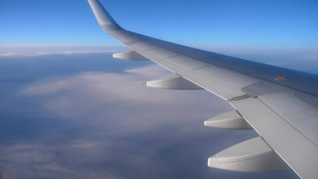 View from the window on the wing of the plane and passing clouds.