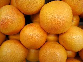 Obraz na płótnie Canvas close-up of a large number of large orange grapefruits in a supermarket top view. citrus fruits