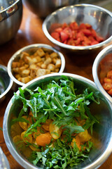 The ingredients are placed in bowls and ready to prepare panzanella salad. Yellow tomatoes, arugula, croutons. Mediterranean kitchen cooking technique.