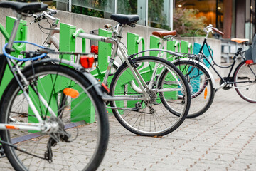 transport and sustainability concept - bicycles at electric bike charging station on city street