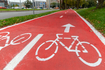 traffic, road marking and city concept - red bike lane with signs of bicycles and two way arrows on street in tallinn