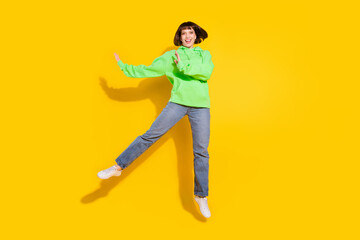 Fototapeta na wymiar Full body photo of attractive young happy woman jump up smile casual outfit isolated on yellow color background