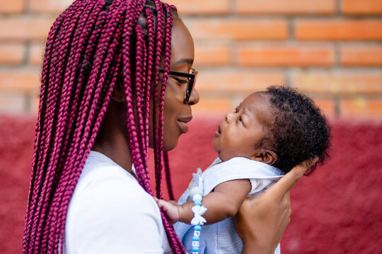Young woman carrying baby boy