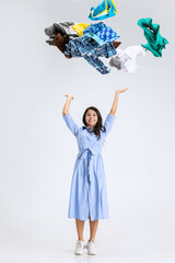 Fototapeta premium One beautiful young girl shopping while black friday sales. Model standing under the clothes falling from above isolated over white background.