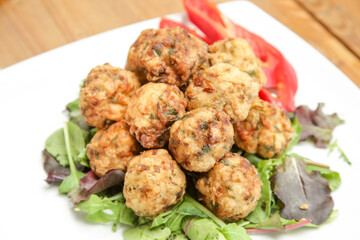 Meatballs served on a plate with green salad
