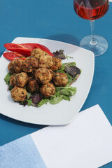 Meatballs served on a plate with green salad