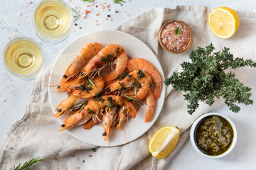 Baked shrimp with pesto sauce, lemon and white wine. Keto diet, gray background