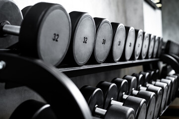 Obraz na płótnie Canvas Close up of new dumbbells on a rack in a gym