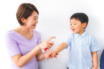 子どもにスプレーをするお母さん