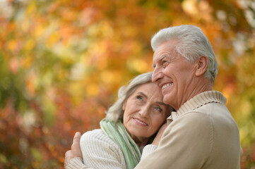 Happy senior couple in autumn park hugging