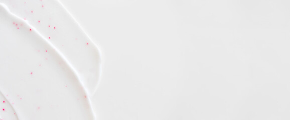 Close-up facial scrub cleanser smear smudge wavy texture on white background with copy space horizontal banner format. Skincare beauty product swatch