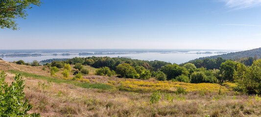 High gently sloping river bank partly covered with forest