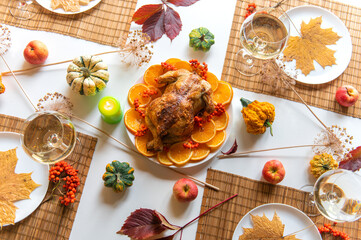 Thanksgiving celebration traditional dinner setting food concept. Top view on roasted turkey on a decorated table.