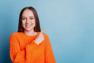 Photo of young pretty lady indicate fingers empty space select suggest sale isolated over blue...