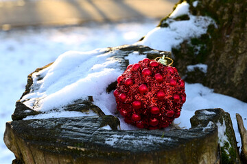 Red Christmas ball toy lying on the snow. Preparing for New Year, decorating  the Christmas tree....