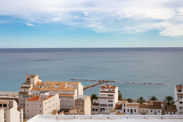 View of the tiled roofs of the village of Altea, overlooking the skyline connecting the sea and blue sky with beautiful clouds, province of Alicante, Spain