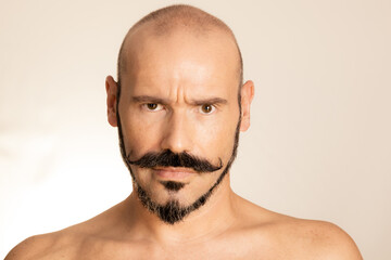 Portrait of Caucasian man with mustache looking at camera. Annoyed or doubtful man stares at you.