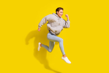 Fototapeta na wymiar Full body photo of funny brown hair young lady run wear sweater jeans sneakers isolated on yellow background