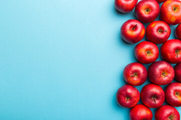 Many red apples on colored background, top view. Autumn pattern with fresh apple above view with copy space for design or text