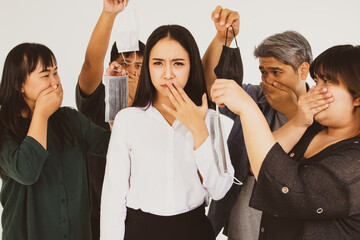 Group of young men and women shows a medical mask to a beautiful woman who does not wear a mask to prevent the influenza, COVID-19, which may spread germs and spread the epidemic.