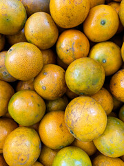 The oranges are piled on the shelves that are sold in the market