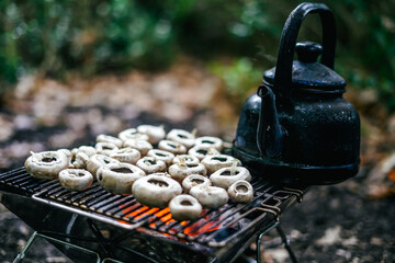 Brown champignon portobello mushrooms being cooked on char grill