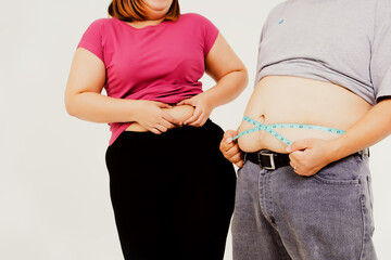Couples with obese and obese sizes squeeze excessive waist and use a waist tape to compare their excess fat : Concept Obesity of men and women who are not healthy.
