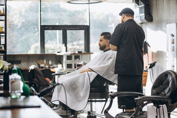 Man getting haircut at the barbershop. Professional barber at work process. Beauty, selfcare, style, fashion, healthcare and male cosmetics concept.
