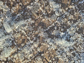 Pieces of broken tempered glass lying on paving slabs closeup background