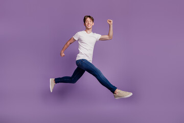 Fototapeta na wymiar Full size profile side photo of young cheerful man jump up fast run walk sale hurry isolated on violet color background