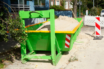 Fototapeta na wymiar Container, grüne Absetzmulde für Bauschutt auf der Straße stehend Deutschland, Europa