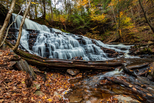 flowing silky cascading waters with  colorful autumn foliage background  on the  woods in Ricketts Glen Pennsylvania