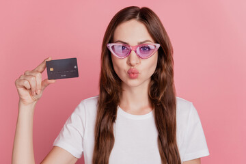 Portrait of romantic charming girl hold credit card send air kiss on pink background