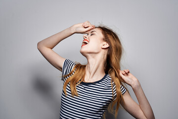 Fototapeta premium pretty woman in a striped t-shirt gesture with his hands isolated background