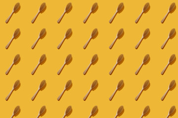 Wooden brush for dry anti-cellulite massage on a colored background. Beauty concept, pattern.