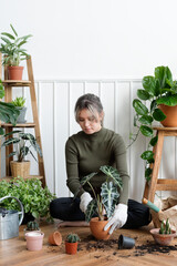 Woman repotting a houseplant inside of her house